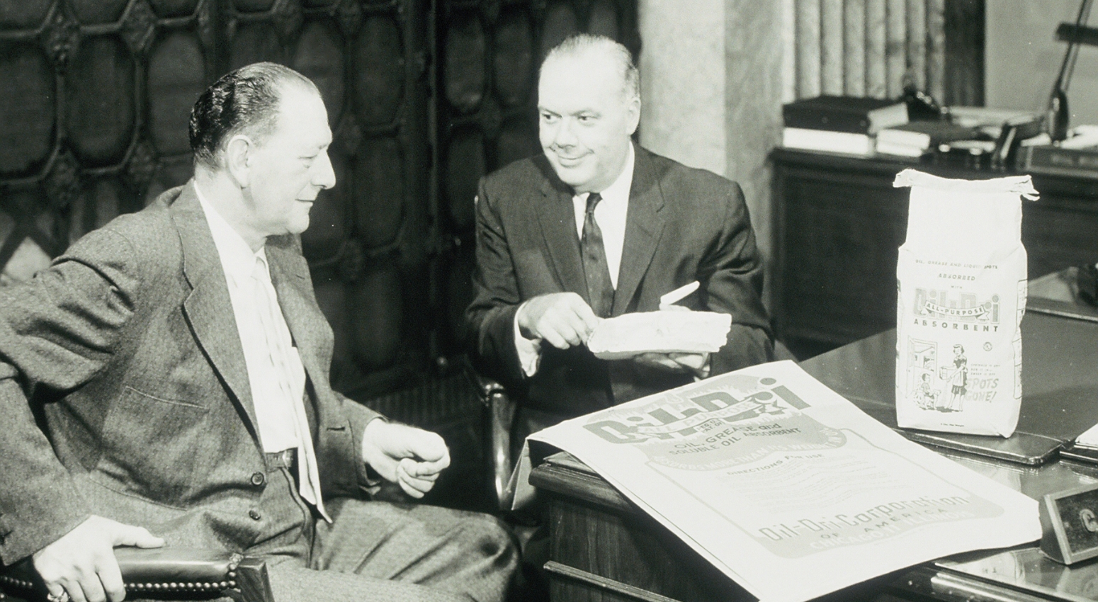 Black and white photo of two business men talking.